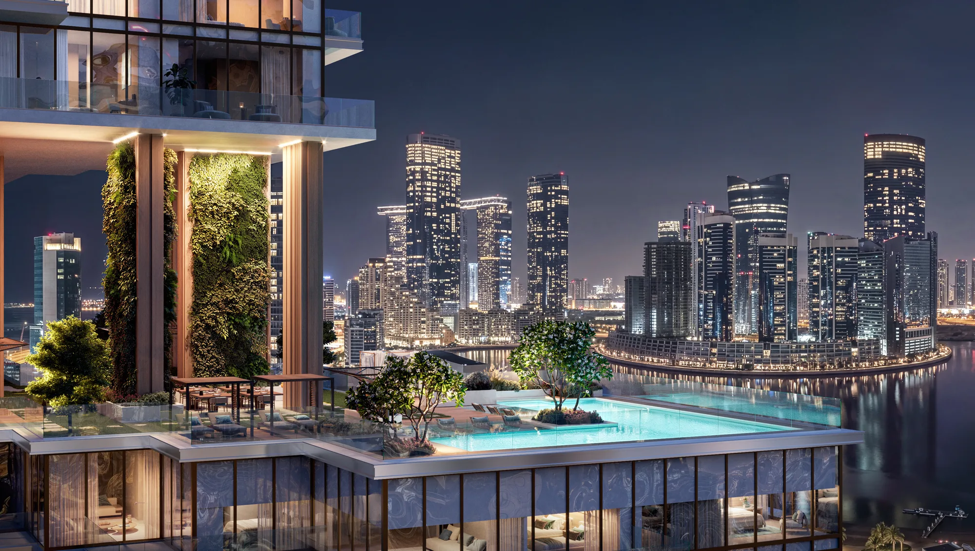 A sky-level pool terrace at night with a green wall, looking over Al Reem Island's towers