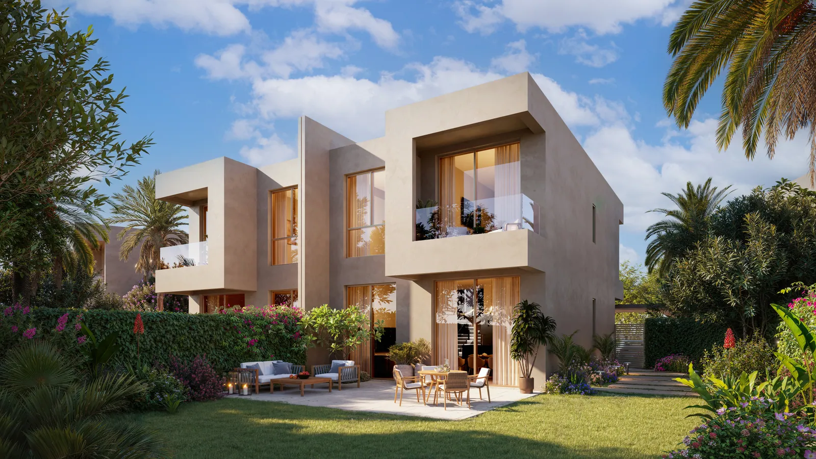 The garden side of a 3-bedroom duplex: two cream two-storey homes with full-height glazing, a terrace with outdoor seating, a lawn and flowering planting