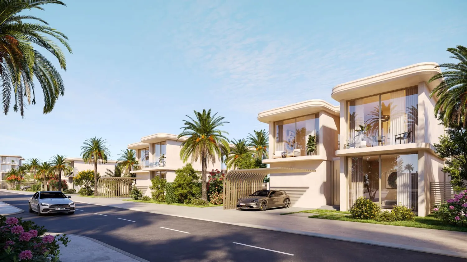 A street of villas: two-storey homes with curved canopies and carports, cars on the road, palms and lawns