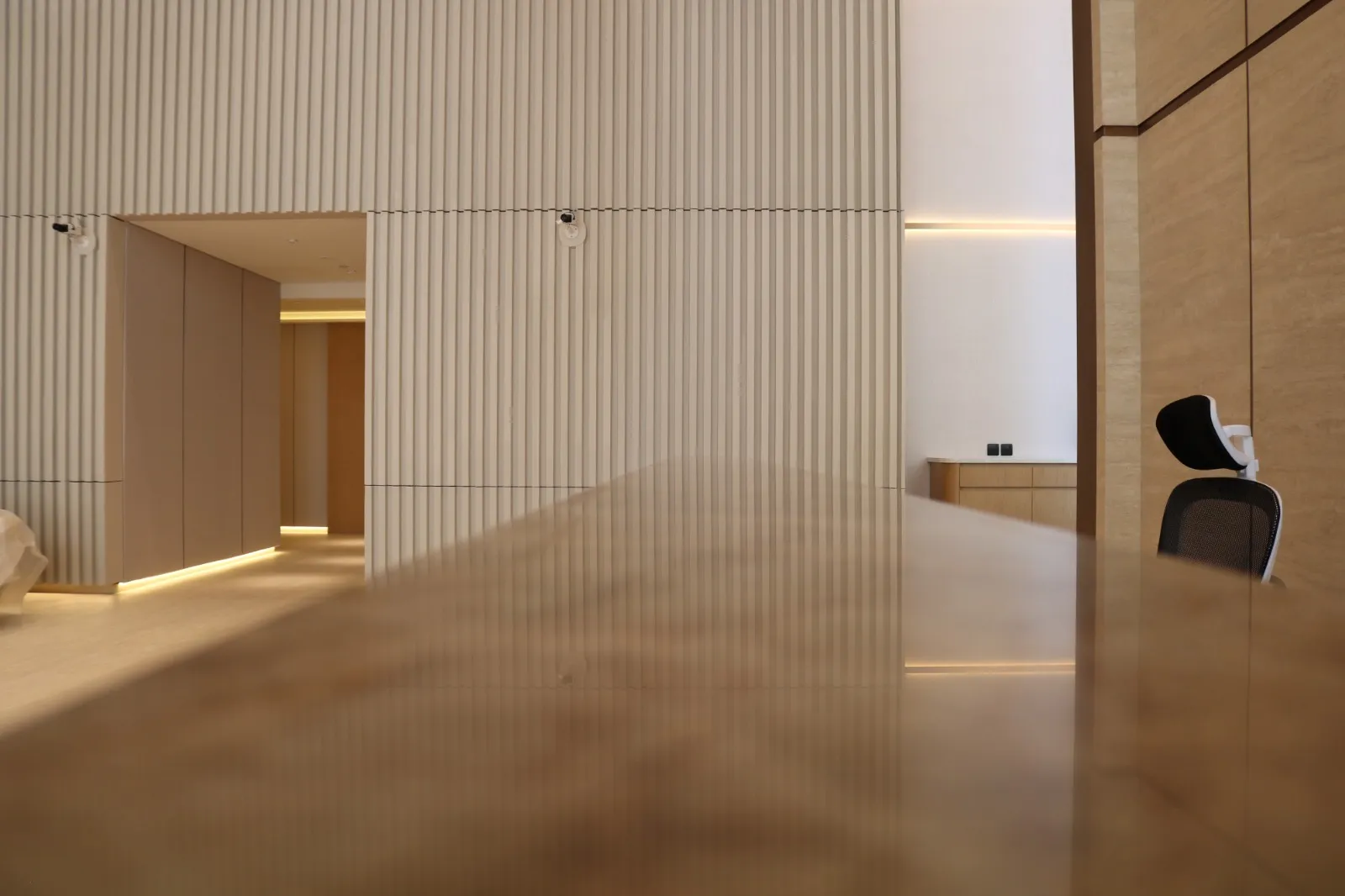 A vestibule of fluted cream panels and a polished floor, with a doorway to the lobby beyond