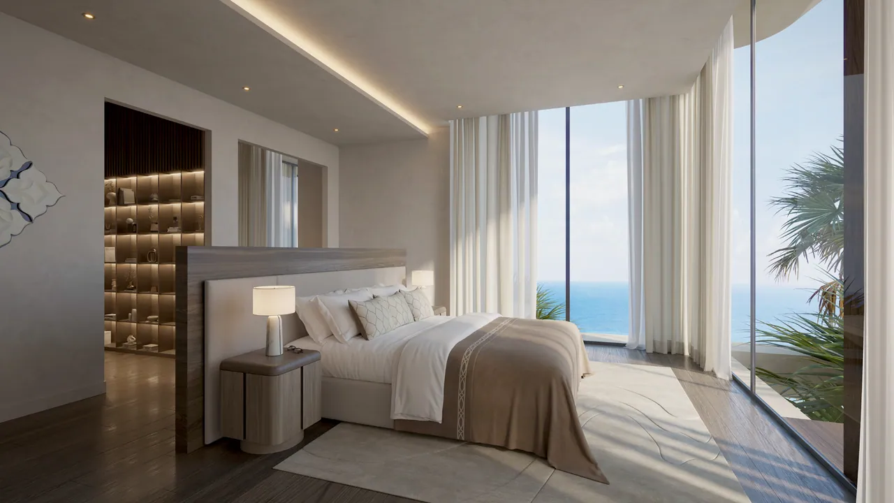 The primary bedroom, the bed facing floor-to-ceiling glass and the sea